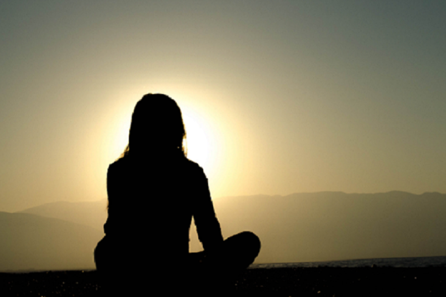 Woman sitting crosslegged meditating
