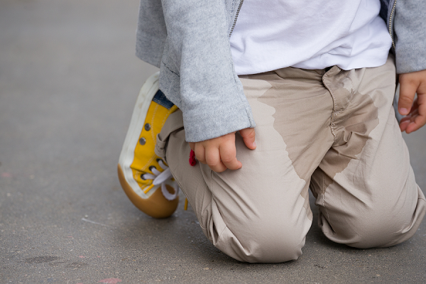 child kneeling wet pants